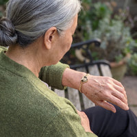 Thumbnail for Woman looking at her husband's photo in the gold heart photo bracelet | SKU: TPH-HRTB-GOLD