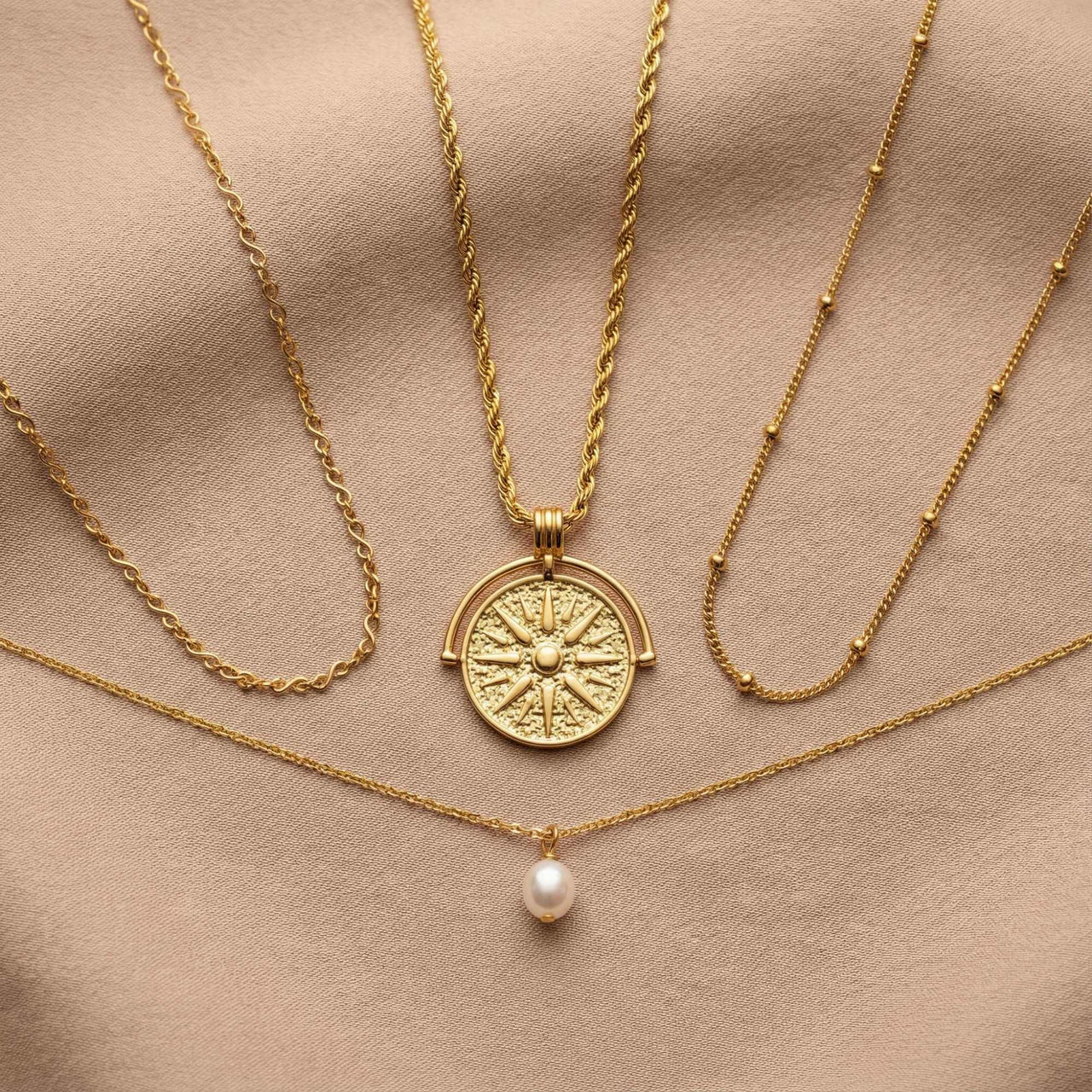 Golden Sun Necklace featuring a textured sun medallion pendant from Brother & Sisters, layered with classic gold chains.