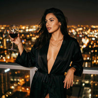 Thumbnail for Model wearing the Saona Triple Layer Necklace by Brother & Sisters, holding a glass of wine, city lights in background.
