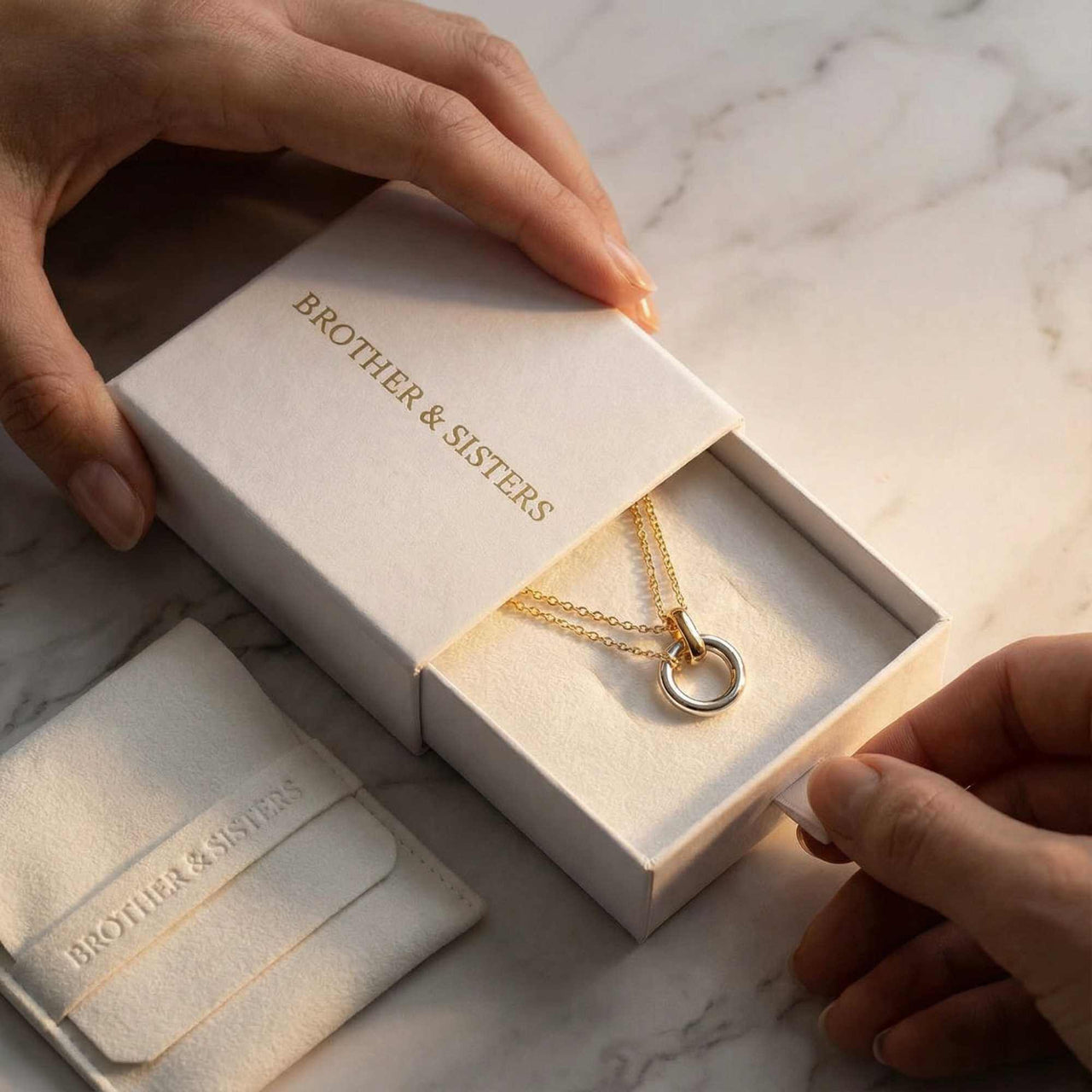 The Unity Bond necklace by Brother & Sisters in elegant packaging, showcasing mixed metal design.