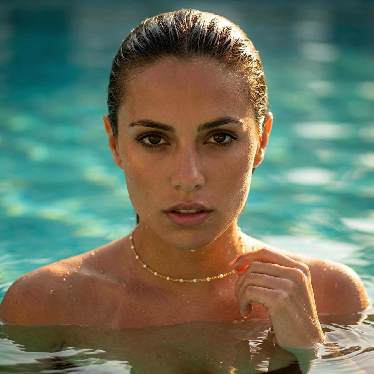 White Beaded Choker worn by a model in water, featuring delicate white enamel beads, by Brother & Sisters.
