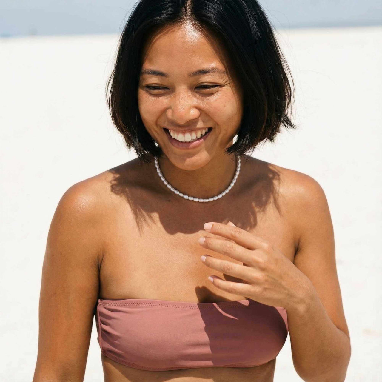 Sun-drenched pearl choker with rose bandeau on Asian model — natural pearls for diverse skin tones