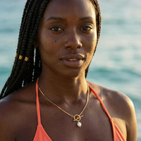 Thumbnail for La Isla Pearl Toggle Necklace worn by a model, featuring a geometric gold toggle and freshwater pearl, by Brother & Sisters.