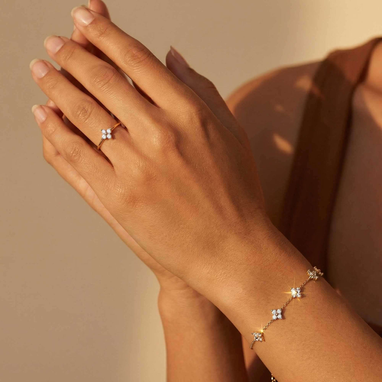 Crystal Flower Ring worn on a hand with a delicate bracelet by Brother & Sisters, featuring brilliant-cut zirconia stones.