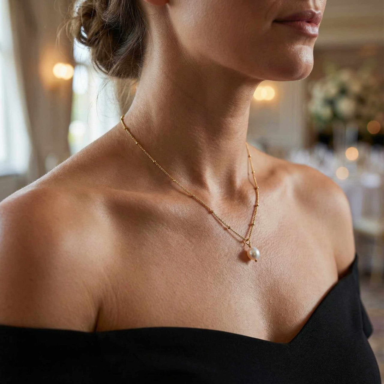 Woman wearing a Pearl Drop Necklace by Brother & Sisters, featuring a freshwater baroque pearl on a textured chain.