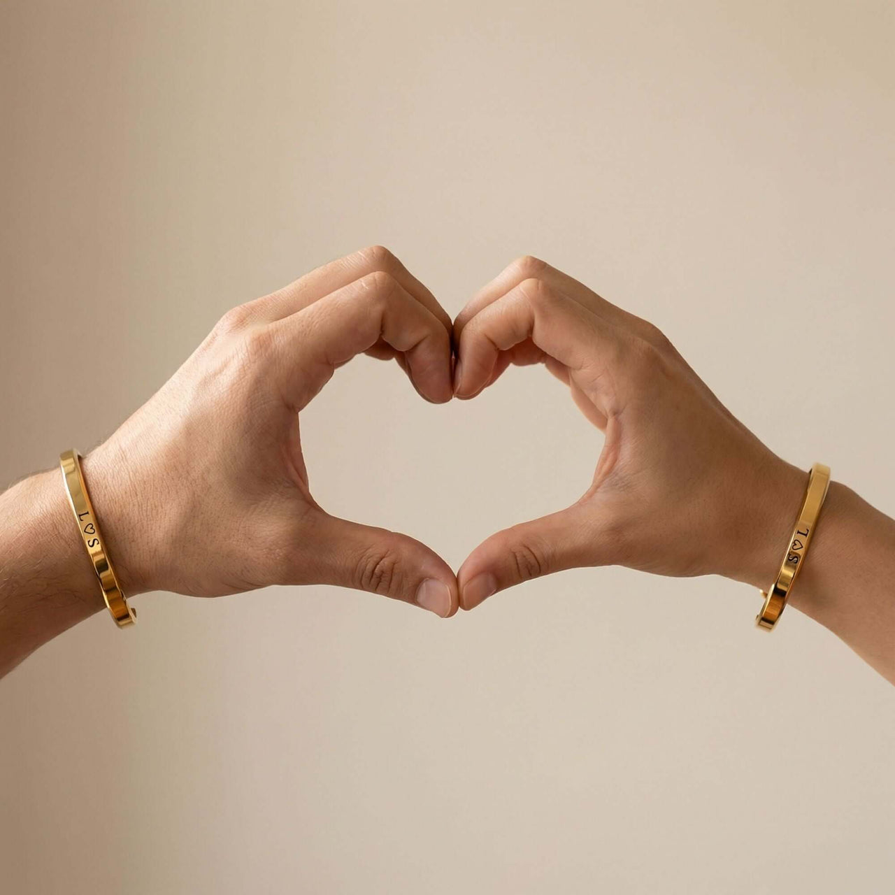 Matching Couple Bracelet by Brother & Sisters, showing hands forming a heart with engraved bracelets.