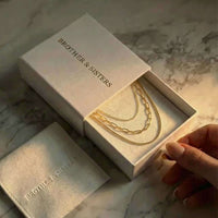 Thumbnail for Saona Triple Layer Necklace by Brother & Sisters in a gift box, showcasing three gold chains.