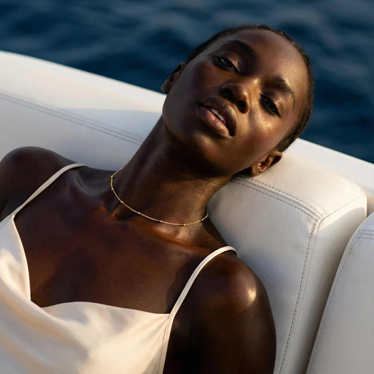 Julia Beaded Chain Necklace worn elegantly, showcasing its whisper-thin chain and golden beads by Brother & Sisters.