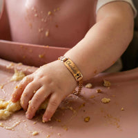 Thumbnail for Infant Bracelet on baby's wrist during mealtime, personalized with name Charlotte, by Brother & Sisters.