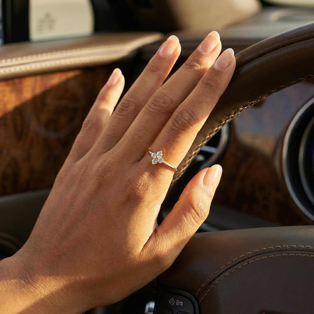 Hand wearing a Crystal Flower Ring by Brother & Sisters, featuring a delicate four-leaf crystal flower design.