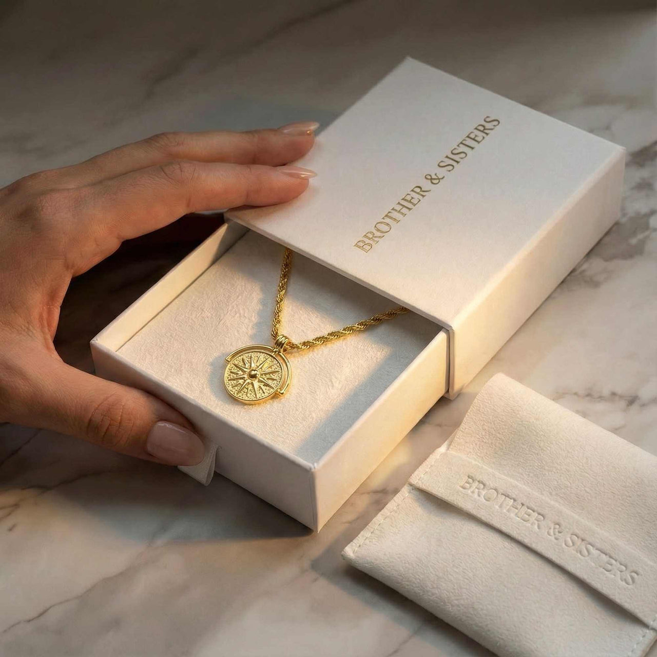 Golden Sun Necklace in a Brother & Sisters gift box, showcasing the sun medallion and classic rope chain.