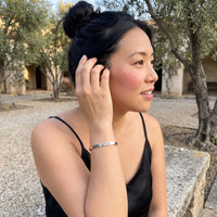 Thumbnail for Woman gently touching her 2020 Survivor bracelet in silver | SKU: 2020s-wg