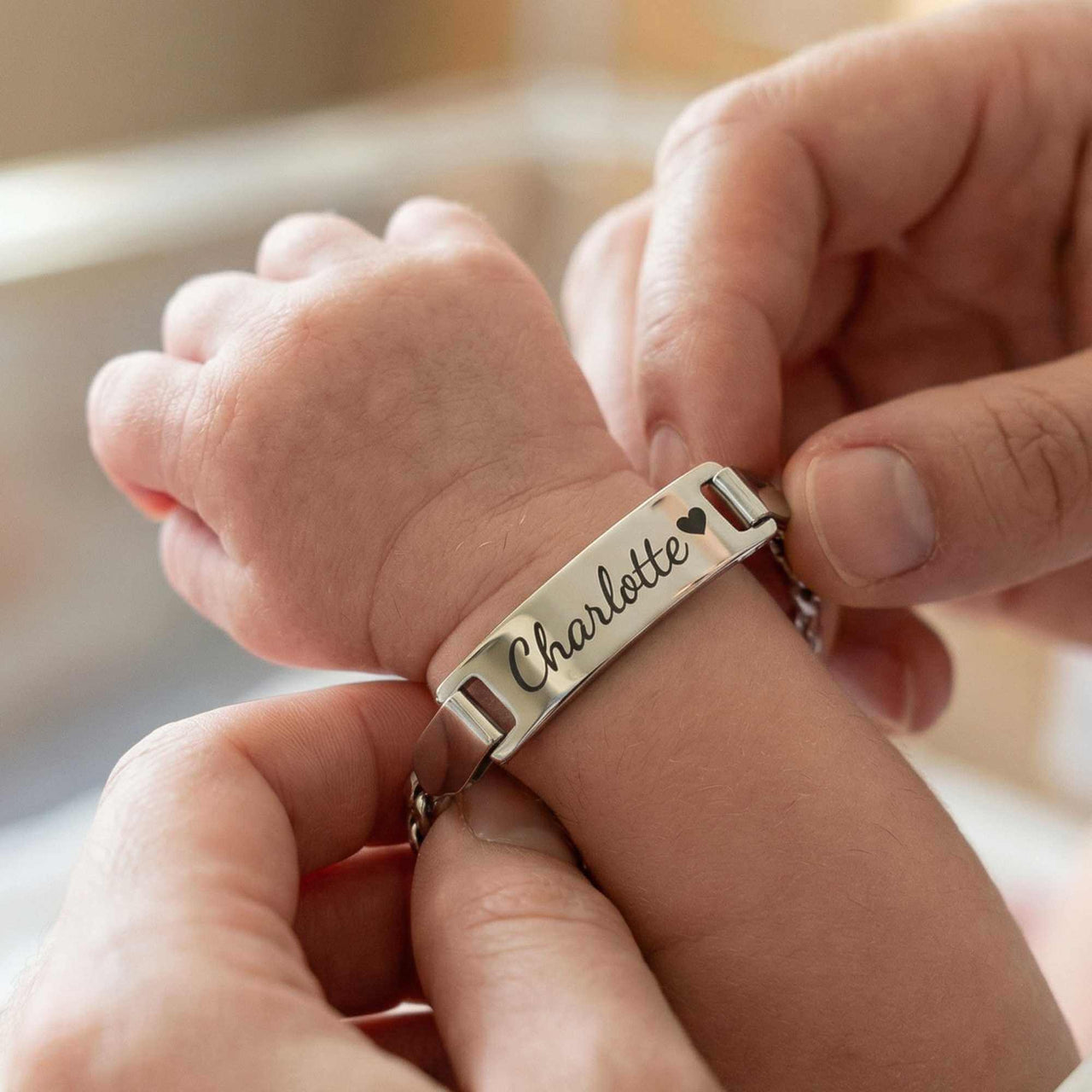 Infant Bracelet from Brother & Sisters on a baby's wrist, personalized with the name Charlotte.