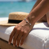 Thumbnail for Crystal Flower Bracelet worn on wrist by a woman, showcasing five sparkling crystal flowers by Brother & Sisters.