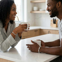 Thumbnail for Couple sharing a moment in the kitchen wearing Infinity Bond Matching Bracelets by Brother & Sisters.