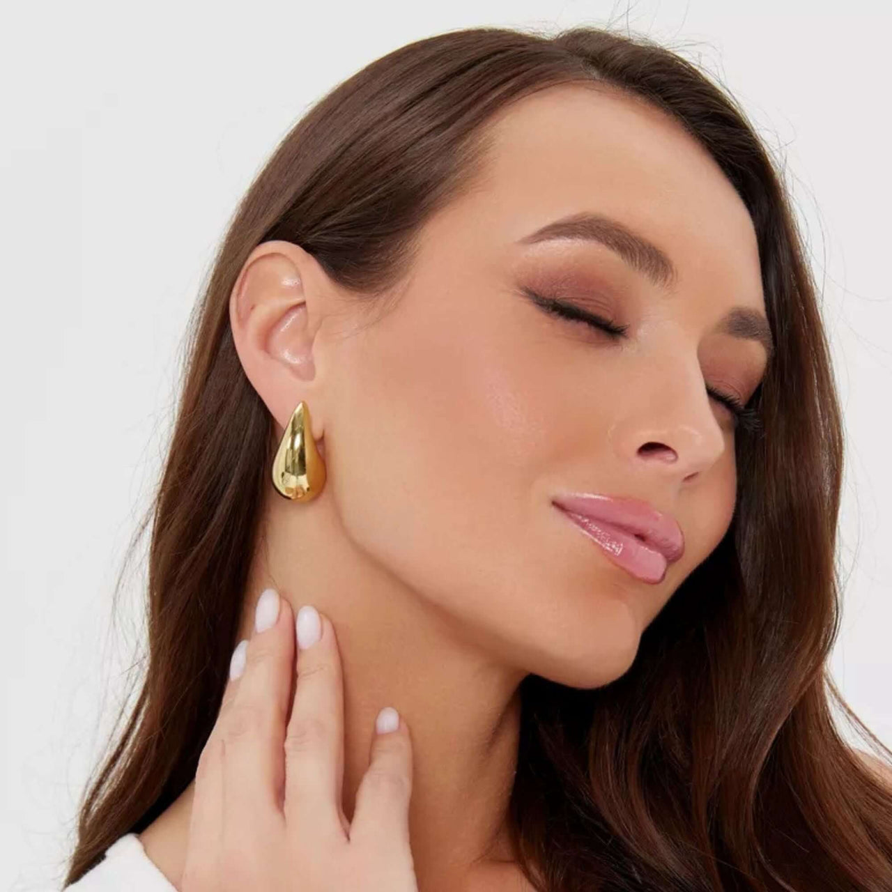 Lumi Drop Studs in gold on a model, showcasing their sculptural teardrop design. By Brother & Sisters.