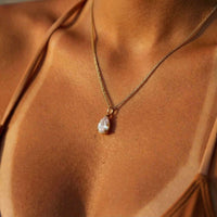 Thumbnail for Astra Teardrop Necklace by Brother & Sisters featuring a shimmering teardrop-cut white stone on a delicate chain.