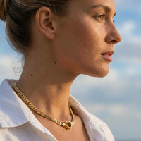 Thumbnail for Vali Heart Choker Necklace worn by a woman featuring a chunky Cuban chain and delicate heart, by Brother & Sisters.