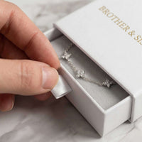 Thumbnail for Hand holding a Crystal Flower Bracelet from Brother & Sisters, beautifully displayed in a white gift box.