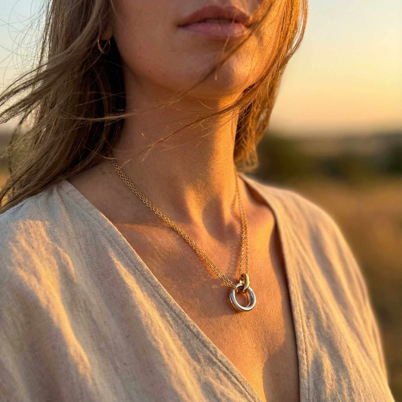 The Unity Bond necklace by Brother & Sisters showcases a polished silver circle and gold bar in elegant harmony.