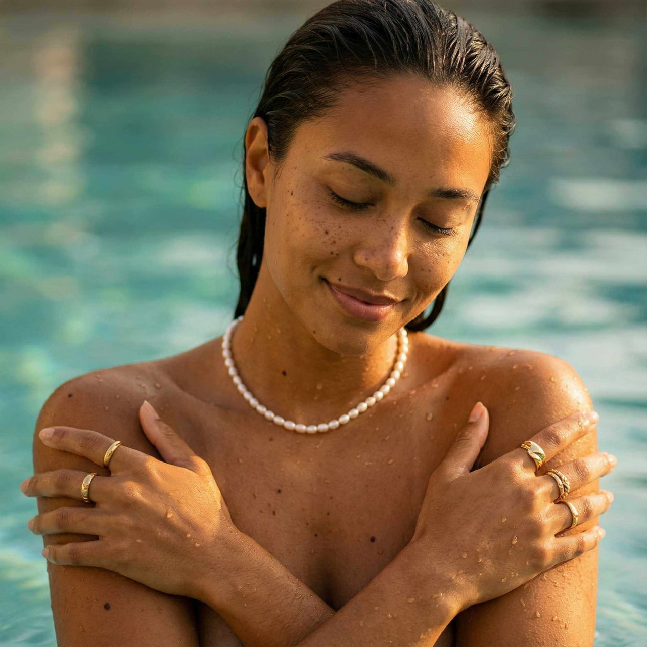 Waterproof pearl choker worn in pool with gold stacking rings — B&S tarnish-free 316L stainless guarantee