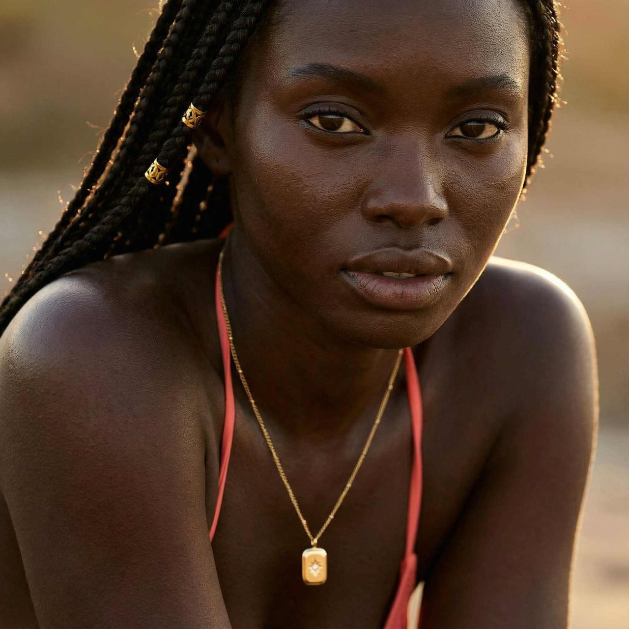 Starlight Pendant Necklace worn by a model, featuring a polished gold tag pendant with a starburst and zirconia stone by Brother & Sisters.