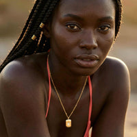 Thumbnail for Starlight Pendant Necklace worn by a model, featuring a polished gold tag pendant with a starburst and zirconia stone by Brother & Sisters.