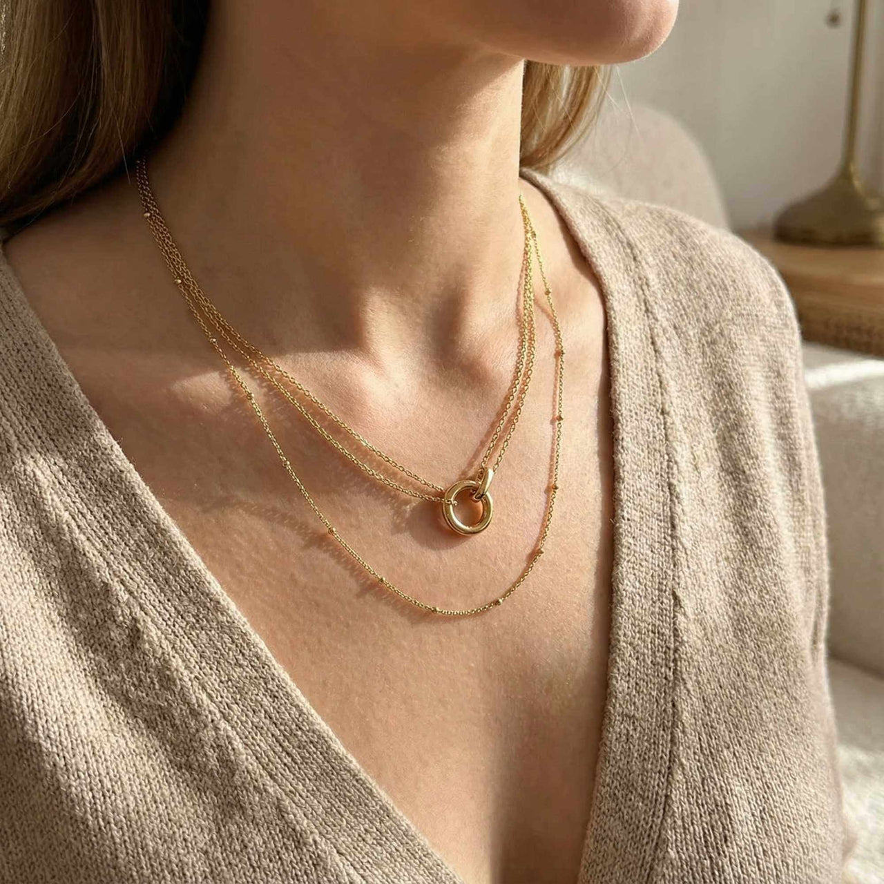 The Eternal Link necklace by Brother & Sisters features delicate gold chains and an interlocking circle pendant.