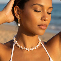 Thumbnail for Model wearing Sunseeker Pearl Choker by Brother & Sisters, featuring irregular baroque pearls on a golden chain.