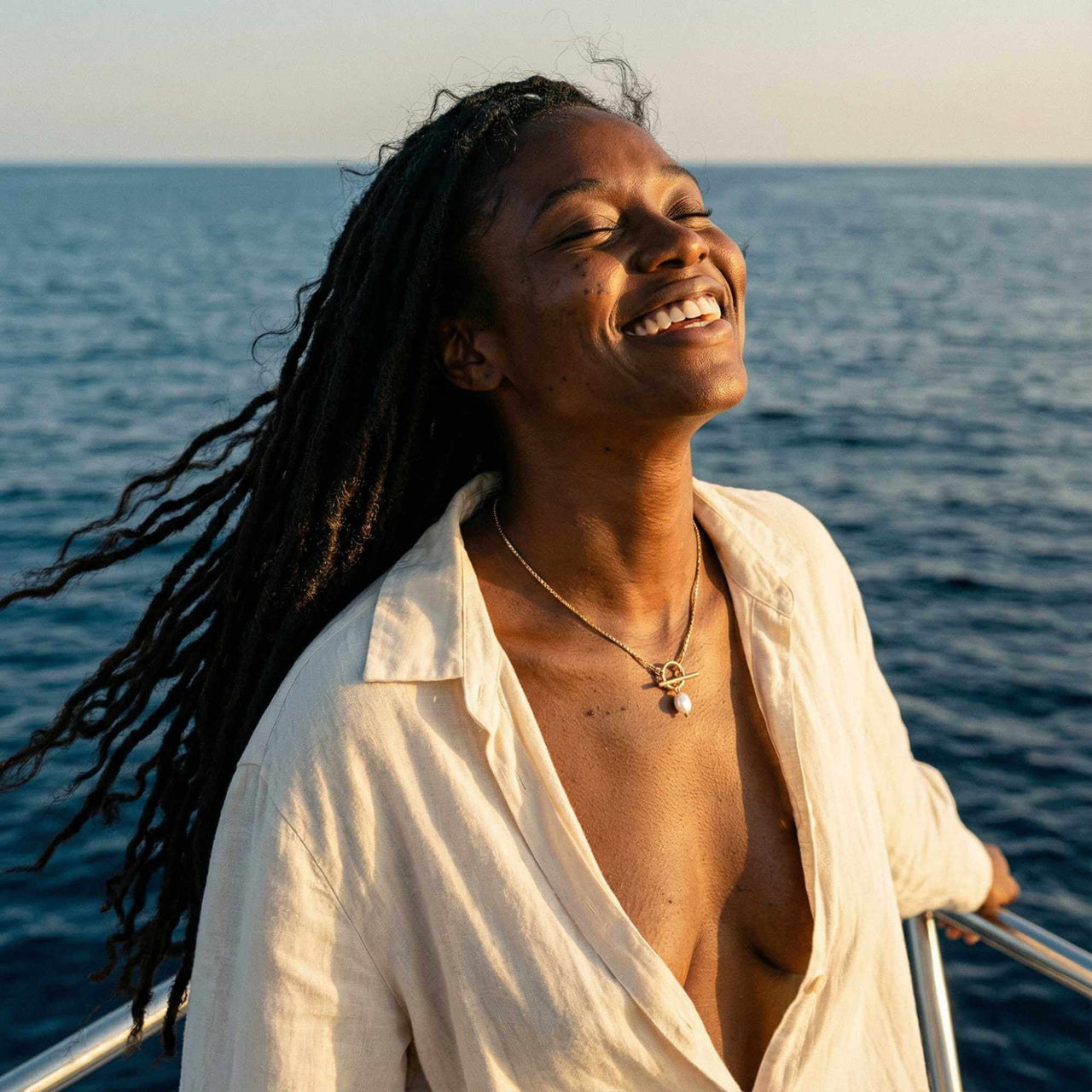 La Isla Pearl Toggle Necklace worn by a woman on a boat, showcasing its unique toggle clasp and freshwater pearl detail.