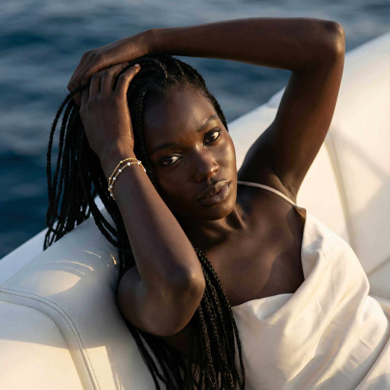 Model showcasing the Double White Bracelet by Brother & Sisters with delicate white enamel beads and gold links.