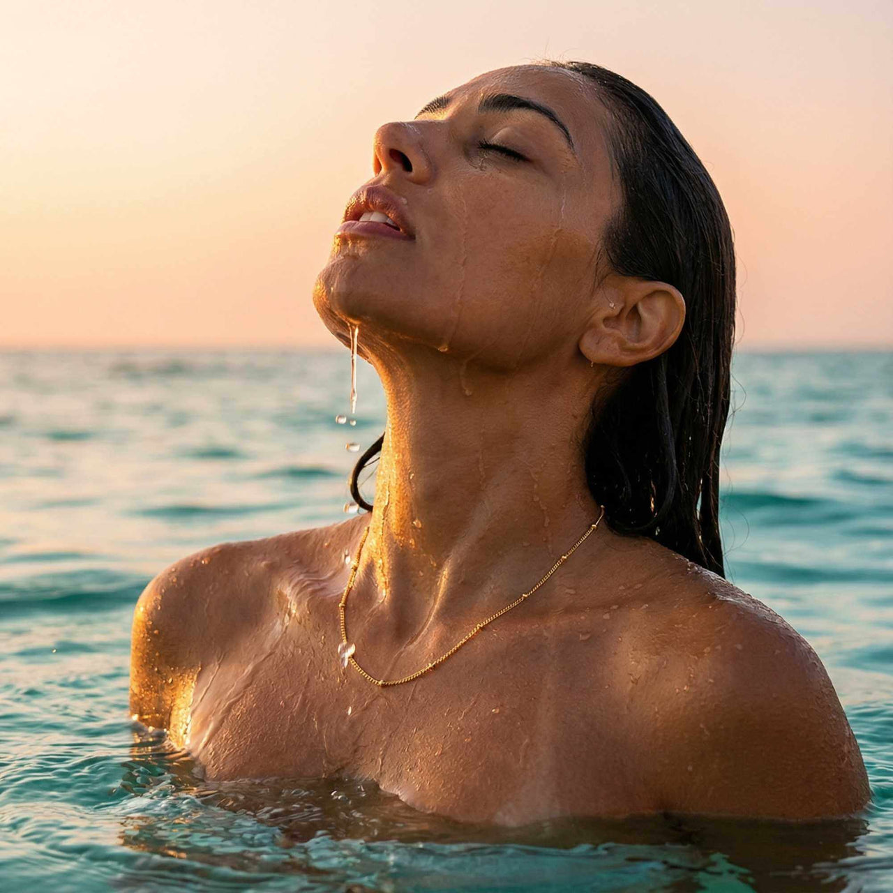 Julia Beaded Chain Necklace worn by a woman in shallow water, highlighting the golden beads and elegant design by Brother & Sisters.