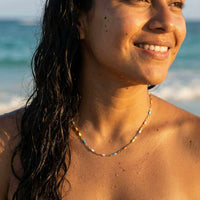 Thumbnail for Rainbow Choker worn on a model at the beach, featuring colorful hand-painted enamel beads by Brother & Sisters.