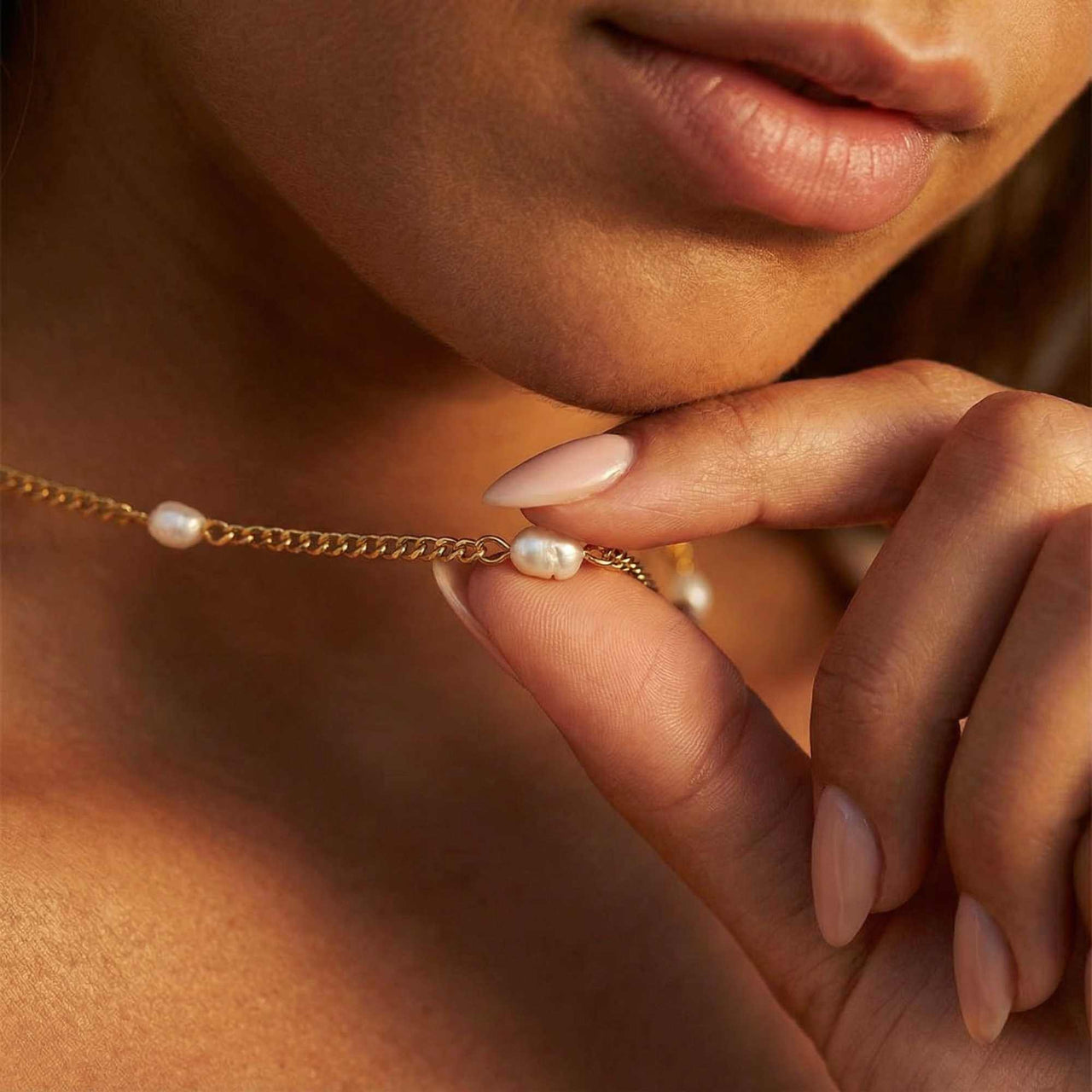 Close-up of a woman holding the Dainty Pearl Choker with tiny freshwater pearls by Brother & Sisters.