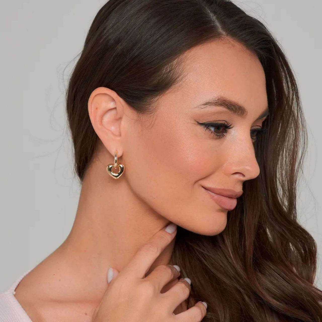 Aurora Heart Hoops worn by a woman, showcasing elegant gold earrings from Brother & Sisters.