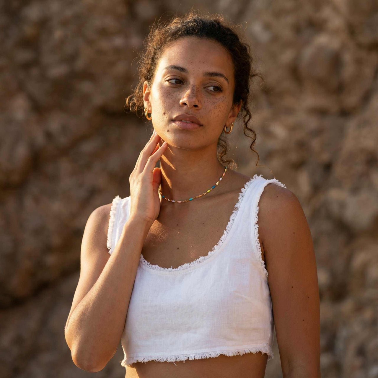 Model wearing a Rainbow Choker from Brother & Sisters, featuring colorful enamel beads on a gold chain.
