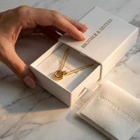 Thumbnail for The Eternal Link necklace by Brother & Sisters, featuring interlocking circle pendant and gold chains in elegant packaging.