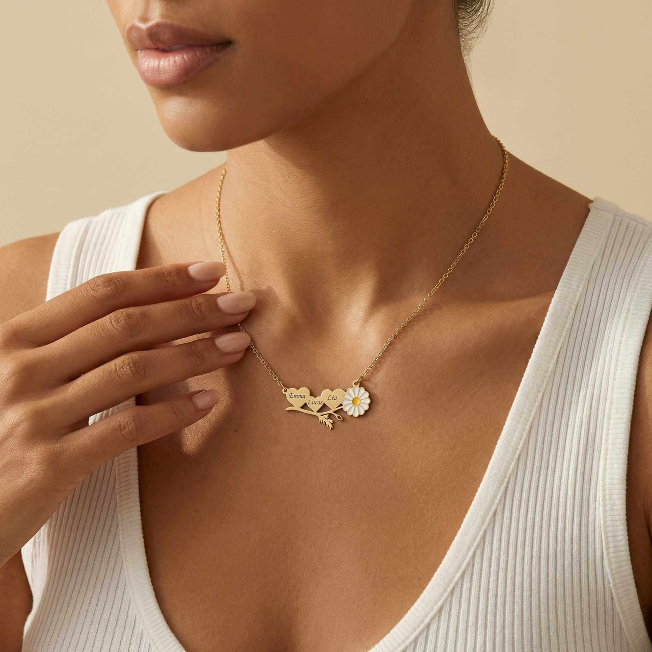 Daisy Name Necklace by Brother & Sisters featuring three hearts and a white enamel daisy, worn elegantly.