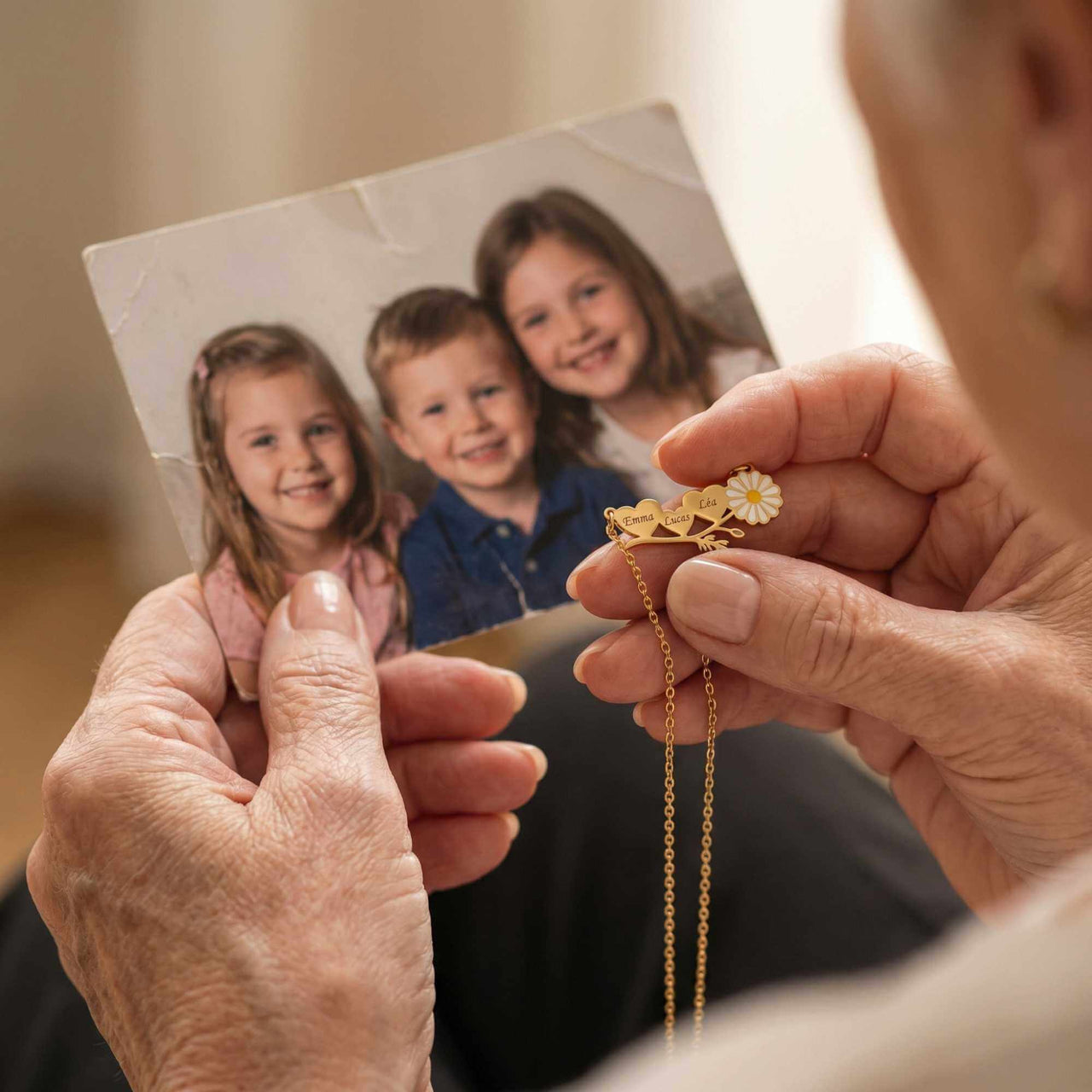 A woman holding a Daisy Name Necklace and a photo of her children, showcasing personal jewellery by Brother & Sisters.