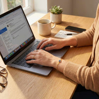 Thumbnail for Person using a laptop while wearing a Photo Projection Bracelet by Brother & Sisters, capturing special memories.