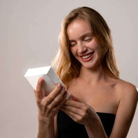 Thumbnail for Happy woman unboxing the Photo Projection Bracelet by Brother & Sisters, showcasing excitement and joy.