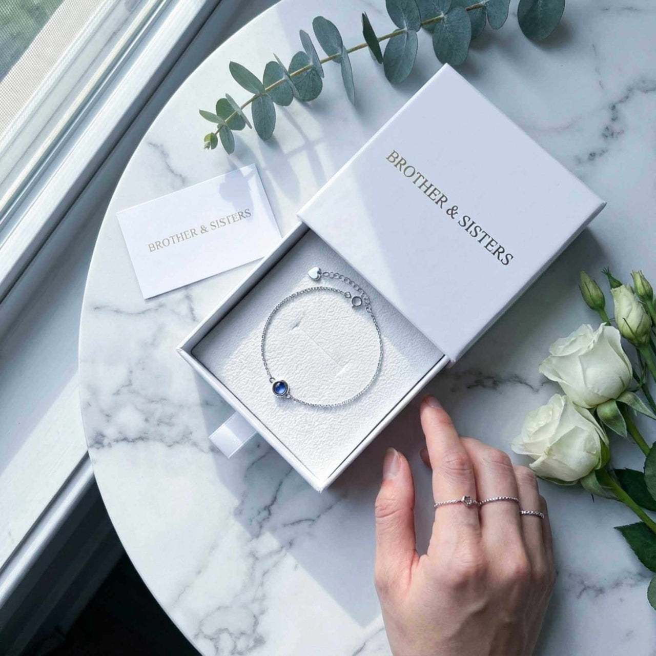 Photo Projection Bracelet by Brother & Sisters in elegant box with greenery and roses.