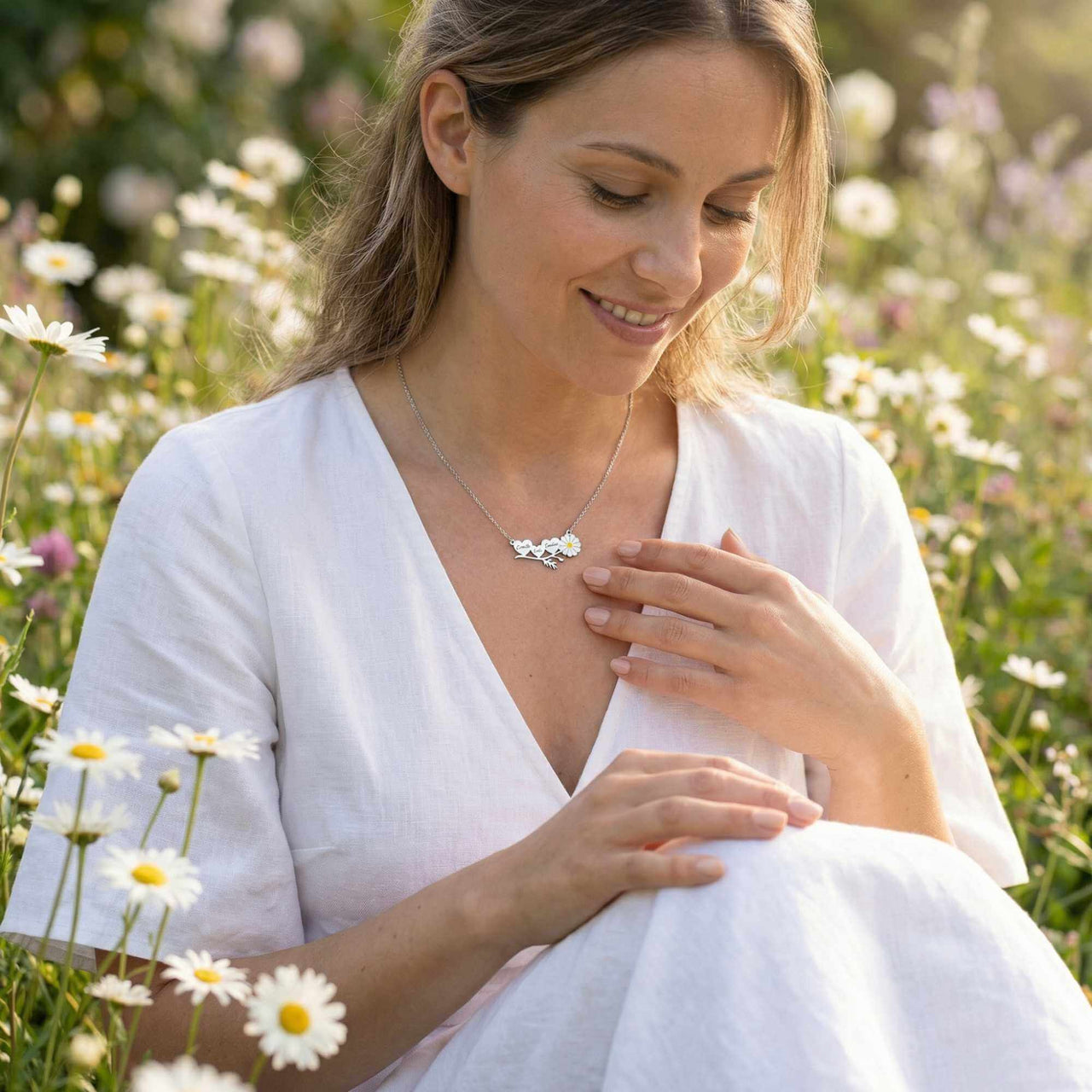 Daisy Name Necklace worn by a woman in a field of daisies, featuring engraved names and a white enamel daisy, by Brother & Sisters.