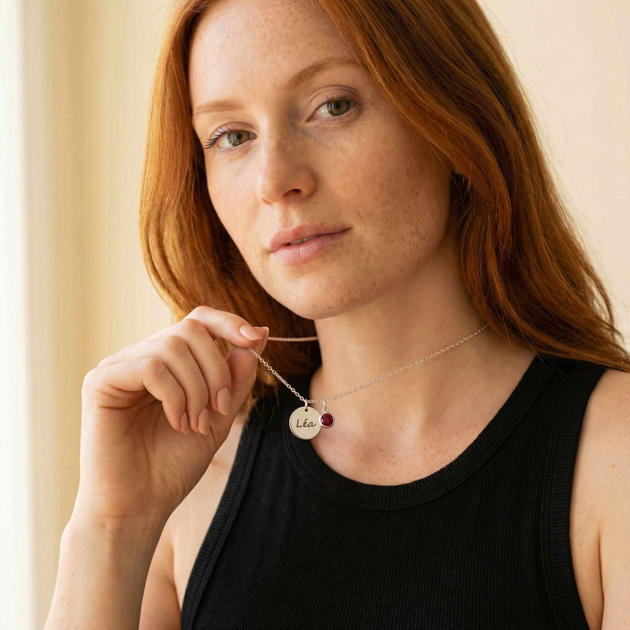 Precious Name Necklace by Brother & Sisters, engraved with name Léa and birthstone, worn by a model.