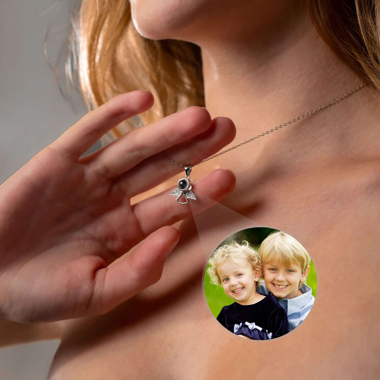 Close-up of Angel Photo Necklace by Brother & Sisters projecting a photo onto a surface.
