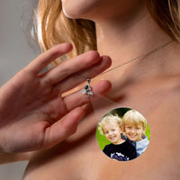Thumbnail for Close-up of Angel Photo Necklace by Brother & Sisters projecting a photo onto a surface.