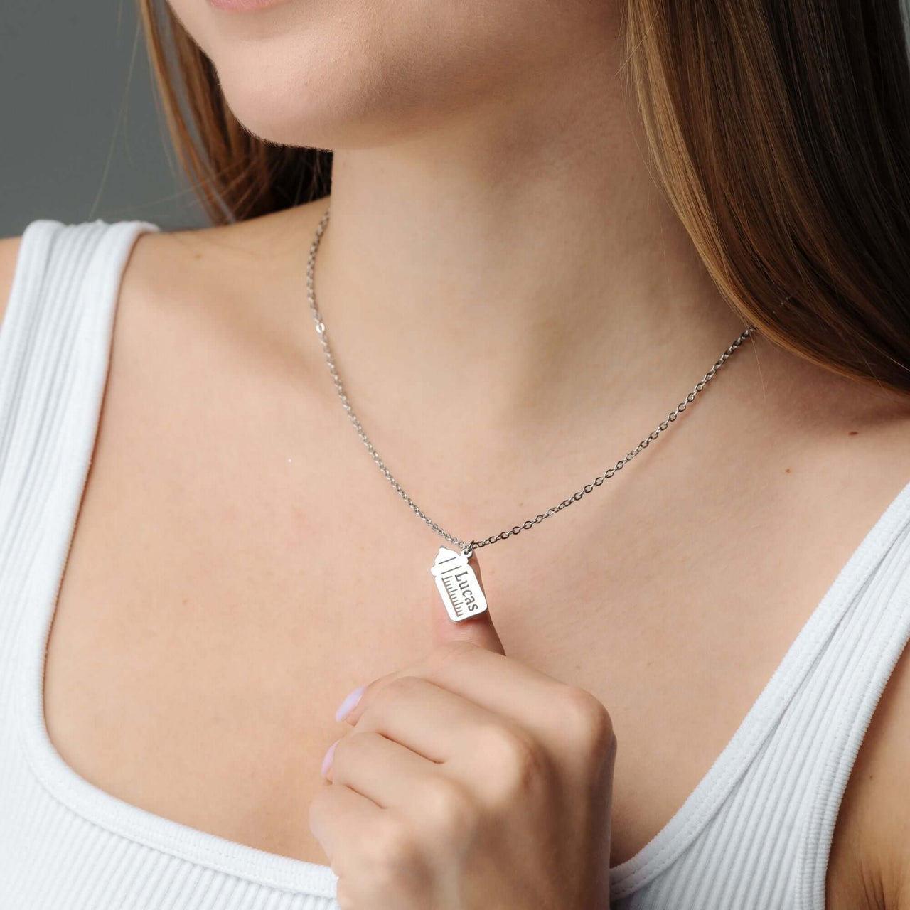 Baby Bottle Name Necklace featuring a customizable bottle-shaped pendant from Brother & Sisters, showcased on a model.