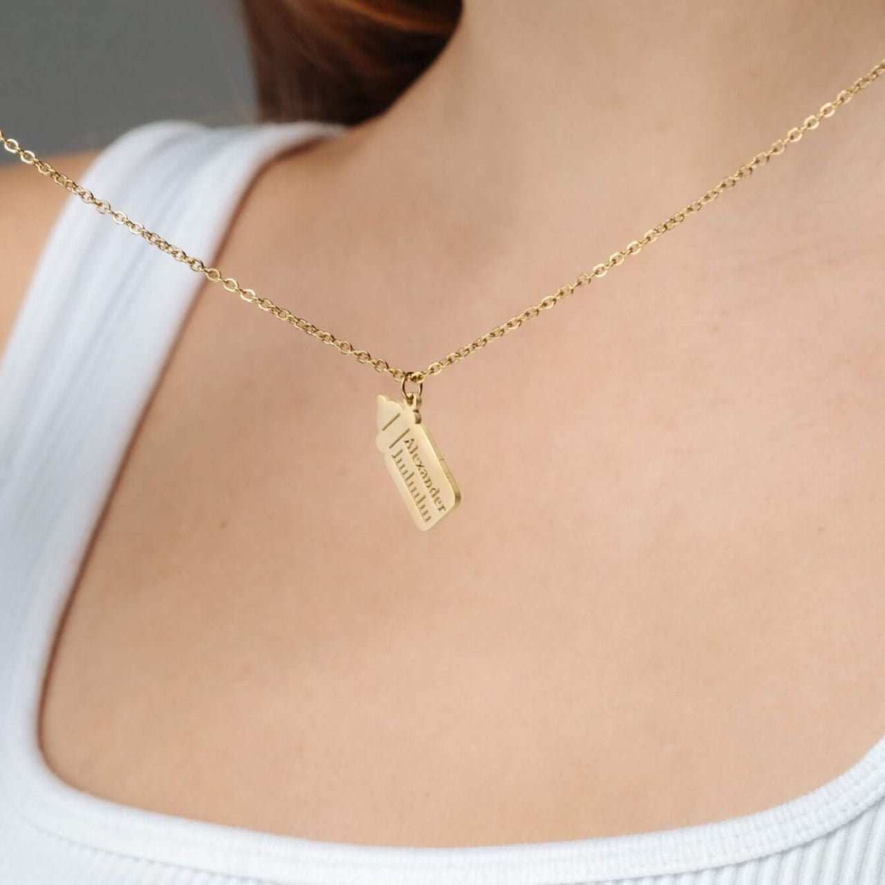 Baby Bottle Name Necklace featuring a gold bottle-shaped pendant on a delicate chain by Brother & Sisters.