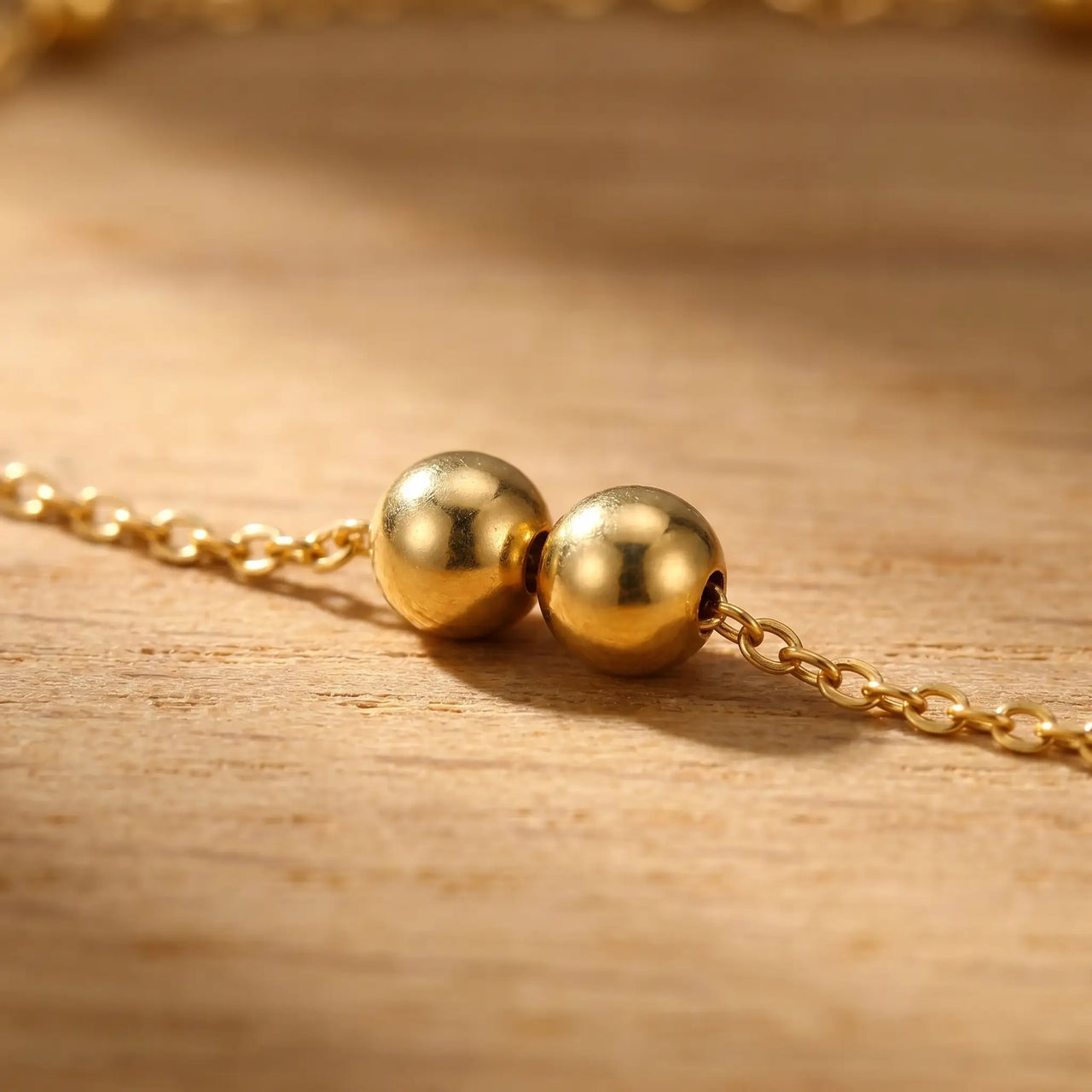 Close-up of paired bead stations on the Beaded Station Anklet by Brother & Sisters, showcasing 18K gold-plated detail.