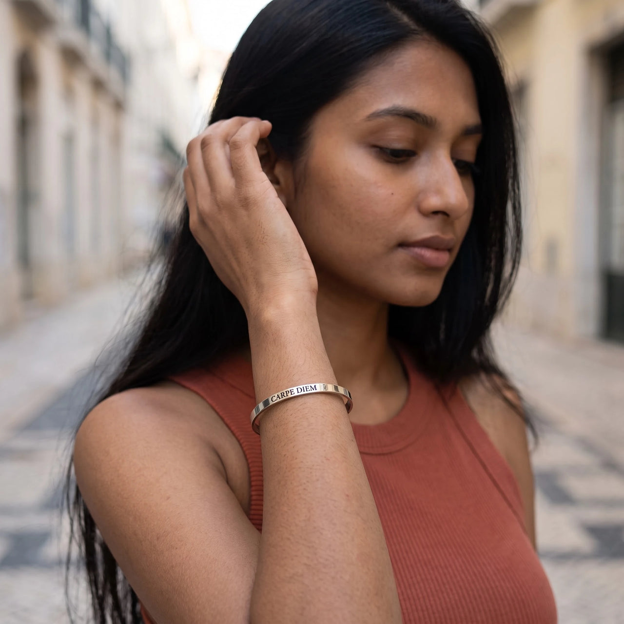 Woman gently touching her Carpe Diem bracelet in silver | SKU: cp-wg